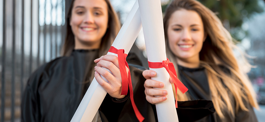 Dos chicas graduadas representando lo que es una mención