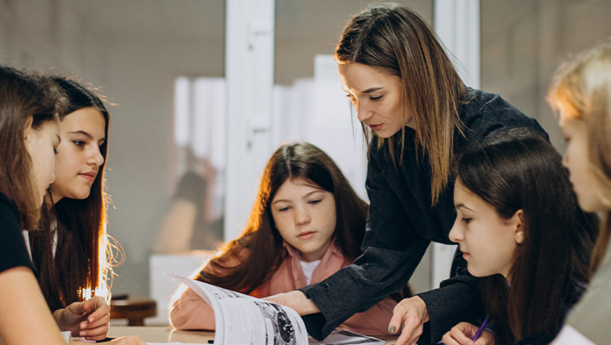 Mujer con alumnos representando qué es la psicopedagogía