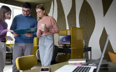 Equipo trabajando en oficina, representando las funciones del departamento de marketing