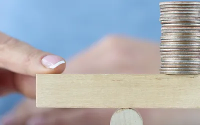 Monedas en una balanza representando qué es el apalancamiento financiero