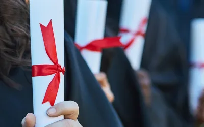 Personas graduadas sujetando el título en representación de qué es una mención en la universidad