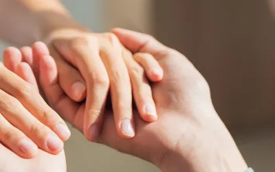 Manos entrelazadas representando la terapia de aceptación y compromiso