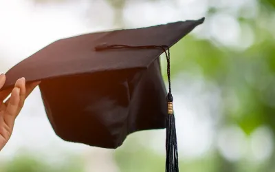 Mano sosteniendo un birrete de graduación
