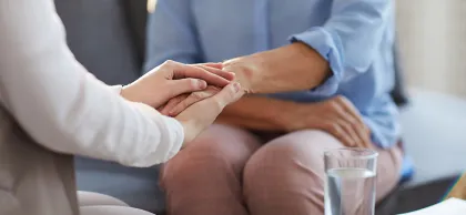 Foto de dos personas dándose la mano en una consulta de psicología