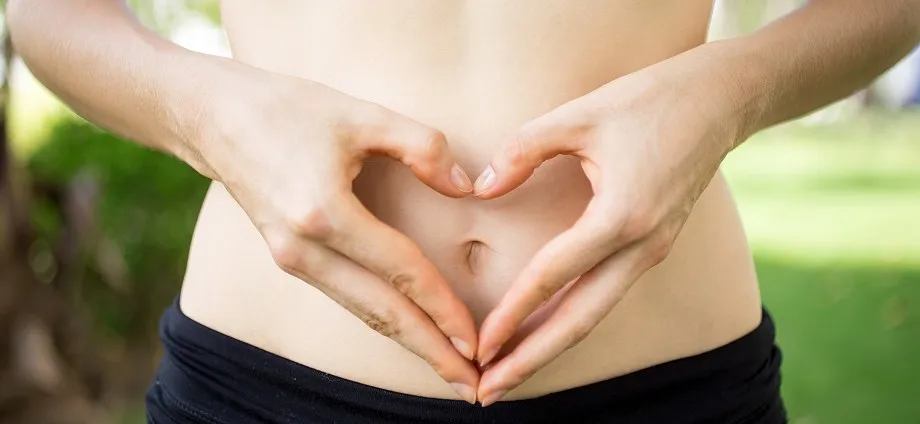 Manos formando un corazón sobre el abdomen