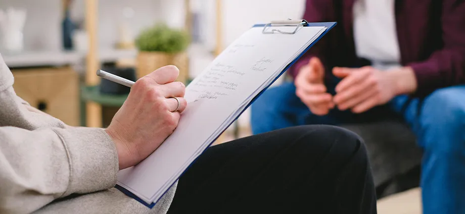 Persona escribiendo en una libreta cómo saber si u psicólogo es bueno 