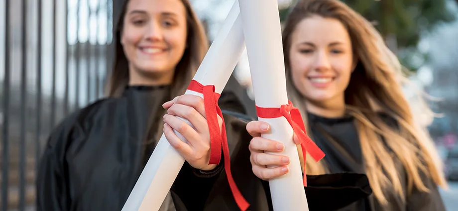 Dos chicas graduadas representando lo que es una mención
