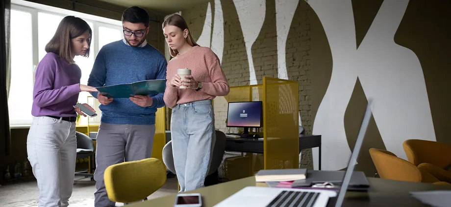 Equipo trabajando en oficina, representando las funciones del departamento de marketing
