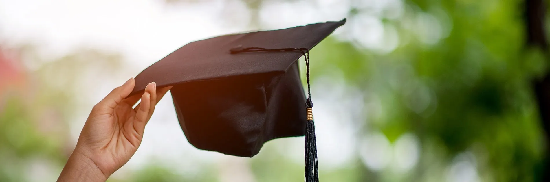 Mano sosteniendo un birrete de graduación