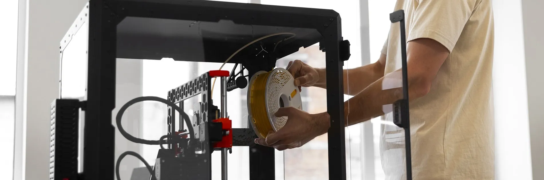 Técnico cargando filamento en una impresora 3D