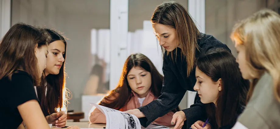Mujer con alumnos representando qué es la psicopedagogía